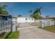 Charming single-story home featuring a gated entrance, white picket fence, and lush landscaping at 7006 N Duncan Ave, Tampa, FL 33604