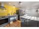 Updated kitchen with stainless steel appliances, yellow subway tile and wood floors at 7006 N Duncan Ave, Tampa, FL 33604