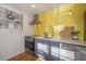 Stylish kitchen with stainless steel appliances, yellow tiled backsplash, and modern fixtures at 7006 N Duncan Ave, Tampa, FL 33604