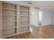 Bright living room showcasing light wood floors and a built-in wooden bookcase at 7006 N Duncan Ave, Tampa, FL 33604