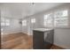 Sun-filled living space with wood floors, white walls, and grey cabinets at 7006 N Duncan Ave, Tampa, FL 33604