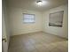 Cozy bedroom featuring neutral tile flooring, natural lighting, and window blinds at 703 E Hamilton Ave, Tampa, FL 33604