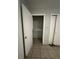 A bedroom closet with shelving and storage, complemented by tile flooring at 703 E Hamilton Ave, Tampa, FL 33604