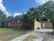 Exterior of a single-story house featuring a long driveway and a well-maintained yard at 703 E Hamilton Ave, Tampa, FL 33604