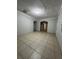 Empty living room featuring neutral tile flooring and natural lighting at 703 E Hamilton Ave, Tampa, FL 33604