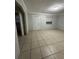 Neutral living room showcasing tile flooring and an entry door to another room at 703 E Hamilton Ave, Tampa, FL 33604