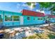 Charming exterior of a colorful home with a red roof and a concrete patio at 7081 Lafayette N, Pinellas Park, FL 33781