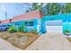 Exterior view showcasing the home's bright paint, red roof, and attached garage at 7081 Lafayette N, Pinellas Park, FL 33781
