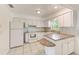 A functional kitchen with white appliances, ample counter space, tile backsplash, and bright lighting at 7081 Lafayette N, Pinellas Park, FL 33781