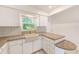 Well-organized kitchen featuring stone countertops, sleek cabinetry, and ample natural light from its window at 7081 Lafayette N, Pinellas Park, FL 33781