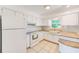 Well-lit kitchen equipped with white cabinetry, stone countertops, modern appliances, and patterned tile flooring at 7081 Lafayette N, Pinellas Park, FL 33781