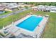 Aerial view of a sparkling blue community pool surrounded by lounge chairs and green lawns at 7081 Lafayette N, Pinellas Park, FL 33781