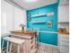 Bright breakfast nook featuring turquoise walls, display shelves, and a custom kitchen island with seating at 7100 Sunset Way # 303, St Pete Beach, FL 33706