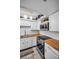 Well-equipped kitchen featuring white cabinets, wooden countertops, stainless steel appliances, and modern lighting fixtures at 7100 Sunset Way # 303, St Pete Beach, FL 33706