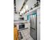 Modern kitchen featuring stainless steel appliances, white cabinetry, custom lighting, and a breakfast bar at 7100 Sunset Way # 303, St Pete Beach, FL 33706