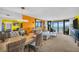 The living room features a modern chandelier, a large sectional, and beautiful ocean views at 7100 Sunset Way # 303, St Pete Beach, FL 33706