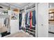Bright walk-in closet featuring custom shelving, ample storage, and convenient access to the en-suite bathroom at 7100 Sunset Way # 303, St Pete Beach, FL 33706