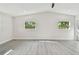 A spacious bedroom with light gray floors, vaulted ceilings, a ceiling fan, and two windows at 7210 8Th N Ave, St Petersburg, FL 33710