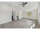 Bright bedroom with modern ceiling fan, gray wood floors, and an ensuite bathroom at 7210 8Th N Ave, St Petersburg, FL 33710