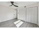 A well-lit bedroom with light gray floors, a ceiling fan, and a closet with louvered doors at 7210 8Th N Ave, St Petersburg, FL 33710