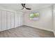 Clean bedroom showcases light gray flooring, closet with bifold doors, a ceiling fan, and a window at 7210 8Th N Ave, St Petersburg, FL 33710