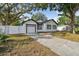 Beautiful home exterior with an automatic white garage door and a well-manicured lawn with a long driveway at 7210 8Th N Ave, St Petersburg, FL 33710