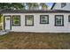 Charming home features a white exterior with black trim, complemented by well-manicured landscaping at 7210 8Th N Ave, St Petersburg, FL 33710