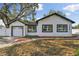Inviting home featuring a pristine white facade, black trim, and an attached garage for convenience at 7210 8Th N Ave, St Petersburg, FL 33710
