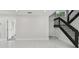 A bright hallway with white tile floors, staircase with metal spindles and an adjacent closet at 7210 8Th N Ave, St Petersburg, FL 33710