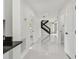 Hallway with sleek tile flooring leading to staircase and other rooms at 7210 8Th N Ave, St Petersburg, FL 33710