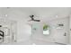 Bright, open living room with a modern ceiling fan, sleek doors, and glossy white tile floors at 7210 8Th N Ave, St Petersburg, FL 33710