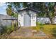 Wooden shed with a deck and lush greenery, perfect for storage or a workshop, surrounded by a white fence at 7210 8Th N Ave, St Petersburg, FL 33710