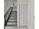 A staircase with wrought iron spindles and gray wood-look steps, along with a louvered closet door at 7210 8Th N Ave, St Petersburg, FL 33710