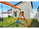 A backyard playset features swings and a slide, perfect for outdoor fun and entertainment at 7331 Canterbury Bells Ct, Tampa, FL 33619