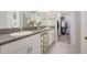 Bathroom featuring double sinks with granite countertop and a walk-in closet for extra storage at 7331 Canterbury Bells Ct, Tampa, FL 33619