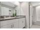 Bathroom featuring double sinks with granite countertop and a door to the toilet and shower at 7331 Canterbury Bells Ct, Tampa, FL 33619