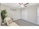 Neutral bedroom with a ceiling fan, white closet doors, and a relaxing lounge area with a modern chair at 7331 Canterbury Bells Ct, Tampa, FL 33619