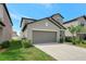 Two-story home featuring a two-car garage, manicured lawn, and well-kept landscaping at 7331 Canterbury Bells Ct, Tampa, FL 33619