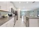 Open kitchen with stainless steel appliances and granite countertops flowing into the living area at 7331 Canterbury Bells Ct, Tampa, FL 33619
