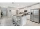 Well-lit kitchen with white cabinets, stainless steel appliances, gray countertop island with bar seating at 7331 Canterbury Bells Ct, Tampa, FL 33619