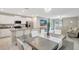 Open-concept kitchen featuring white cabinets, granite countertops, stainless steel appliances, and adjacent dining area at 7331 Canterbury Bells Ct, Tampa, FL 33619
