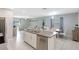 Spacious open-concept living area featuring a kitchen island with bar seating, modern decor, and tile flooring at 7331 Canterbury Bells Ct, Tampa, FL 33619