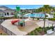 A vibrant splash pad features play equipment next to a large community pool, great for Gathering fun at 7331 Canterbury Bells Ct, Tampa, FL 33619