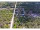 High angle shot of property displaying buildings, open land and lush tree coverage at 9802 Eden Ave, Hudson, FL 34667