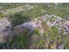 Aerial view of a property with wooded areas and open spaces on a sunny day at 9802 Eden Ave, Hudson, FL 34667
