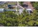 Aerial view of lot with structures, tree coverage, driveway, and fencing at 9802 Eden Ave, Hudson, FL 34667