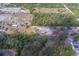 Aerial view of a property with a house and outbuildings surrounded by wooded areas and open spaces at 9802 Eden Ave, Hudson, FL 34667