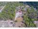 An expansive aerial view of the property with the house and outbuildings in a treed lot at 9802 Eden Ave, Hudson, FL 34667