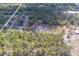 Wide aerial view of the property with buildings, lush greenery and surrounding tree coverage at 9802 Eden Ave, Hudson, FL 34667