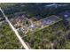 Aerial view of the property outlined, showing buildings, open land, and lush green tree coverage at 9802 Eden Ave, Hudson, FL 34667